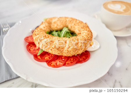Turkish breakfast with simit, cheese, tomato, cucumber, olives. Breakfast with coffee in the restaurant. Morning nutritious meal Turkish breakfast with simit, cheese, tomato, cucumber, olives. Breakfast with coffee in the restaurant. Morning nutritious meal 105150294