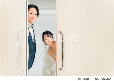 会場のゲスト・友達をドアから覗き見する・扉から顔を出す新郎新婦 会場のゲスト・友達をドアから覗き見する・扉から顔を出す新郎新婦 105150362