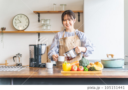 朝キッチンでコーヒーを淹れるエプロン姿のアジア人女性 朝キッチンでコーヒーを淹れるエプロン姿のアジア人女性 105151441
