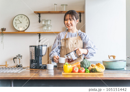 朝キッチンでコーヒーを淹れるエプロン姿のアジア人女性 朝キッチンでコーヒーを淹れるエプロン姿のアジア人女性 105151442