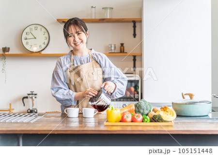朝キッチンでコーヒーを淹れるエプロン姿のアジア人女性 105151448
