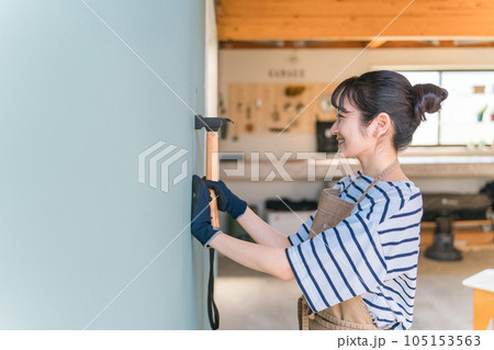 ガレージに釘を打つ日本人女性(リノベーション・DIY) ガレージに釘を打つ日本人女性(リノベーション・DIY) 105153563