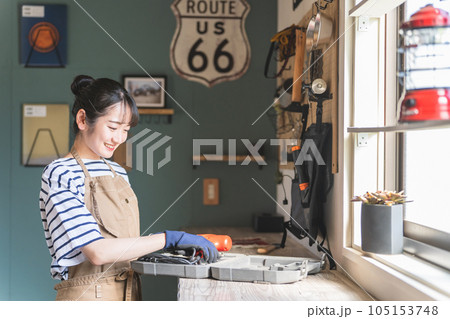 家のガレージで工具を使う女性（DIY・クラフト・日曜大工・ワークショップ・体験教室・リフォーム） 105153748
