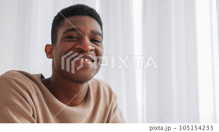 Video call. Virtual meeting. Positive attitude. Joyful optimistic cheerful young man in good mood with happy toothy smile at window copy space. 105154233
