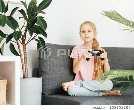 Girl playing video game at home 105155107