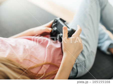 Girl playing video game at home 105155108