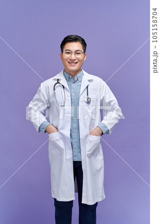 Handsome young doctor in a dressing gown with a stethoscope on a purple background 105158704