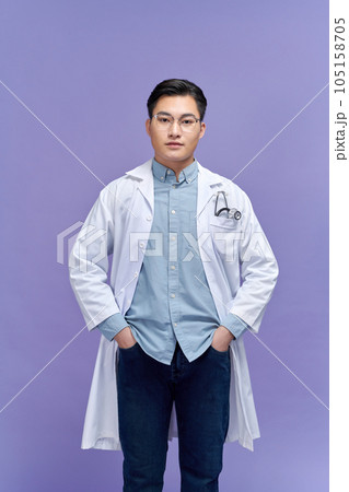 Handsome young man wearing doctor uniform with a happy and cool smile on face 105158705