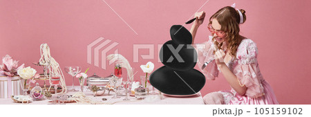 One hungry queen wearing baroque dress starting eat food with knife in hand on laid festive table over pink studio background. Bloodthirsty princess 105159102