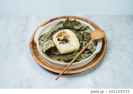 yeonnipbap, korean lotus leaf rice, Glutinous rice, dates, and chestnuts wrapped in a lotus leaf and steamed in a steamer. In the past, this dish was made and consumed by Buddhist monks, but it is now yeonnipbap, korean lotus leaf rice, Glutinous rice, dates, and chestnuts wrapped in a lotus leaf and steamed in a steamer. In the past, this dish was made and consumed by Buddhist monks, but it is now 105159535