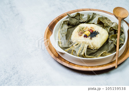 yeonnipbap, korean lotus leaf rice, Glutinous rice, dates, and chestnuts wrapped in a lotus leaf and steamed in a steamer. In the past, this dish was made and consumed by Buddhist monks, but it is now yeonnipbap, korean lotus leaf rice, Glutinous rice, dates, and chestnuts wrapped in a lotus leaf and steamed in a steamer. In the past, this dish was made and consumed by Buddhist monks, but it is now 105159538