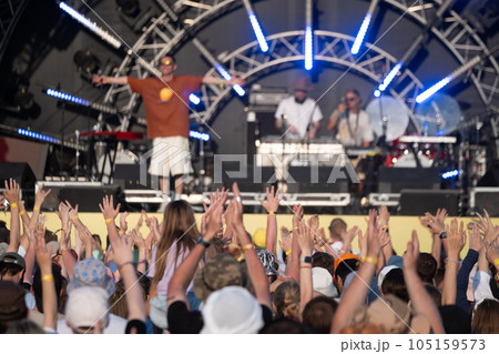 Raised arms of fans and musicians on stage 105159573