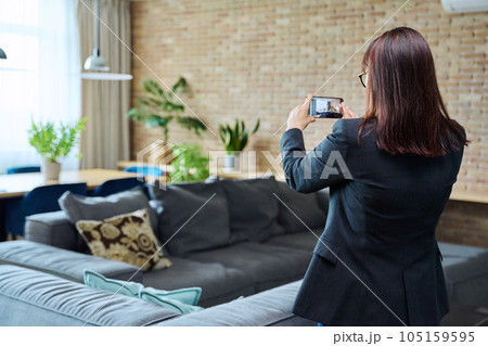 Woman real estate agent photographing furnished apartment Woman real estate agent photographing furnished apartment 105159595