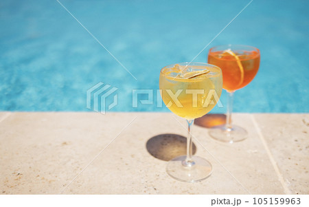 Two glass of delicious cocktails against poolside at resort hotel. Two glass of delicious cocktails against poolside at resort hotel. 105159963