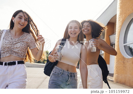 Close up of three teenage girls in casual clothes drinking tasty lemonade on the go 105159972