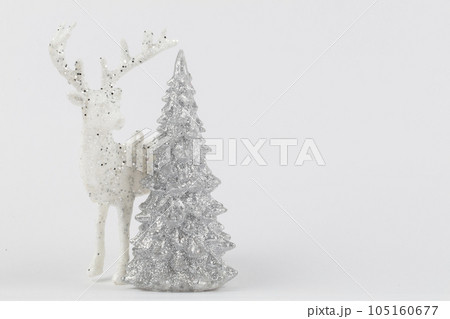 Muted holiday background. On a gray background, a silver tree and a white Christmas deer. 105160677