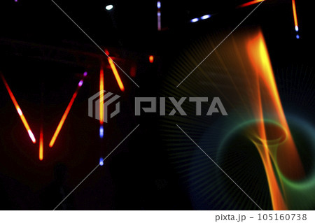Colored multicolored rays and swirls from the stage light on a dark background. 105160738
