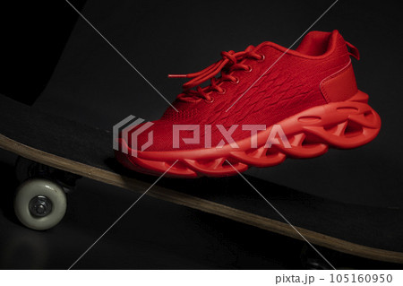 Red fabric sneaker on a skateboard close-up. 105160950