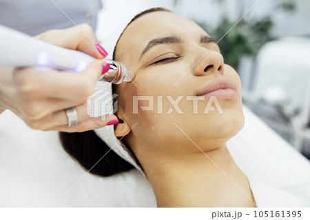 Brunette young woman undergoes a procedure of vitamin peeling 105161395