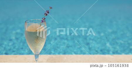 Glass of champagne with sprig of lavender against poolside at resort hotel during vacation 105161938