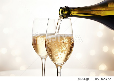 Champagne pouring from a bottle into wine glass isolated on white background 105162372