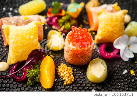 Salted Scottish salmon with trout roe. Marinated cucumber and onion, wonton chips. Delicious healthy Italian traditional food closeup served for lunch in modern gourmet cuisine restaurant Salted Scottish salmon with trout roe. Marinated cucumber and onion, wonton chips. Delicious healthy Italian traditional food closeup served for lunch in modern gourmet cuisine restaurant 105163711
