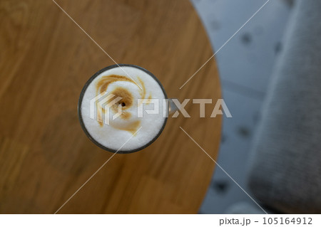 Coffee in blue cup on wooden table in cafe with lighting background 105164912