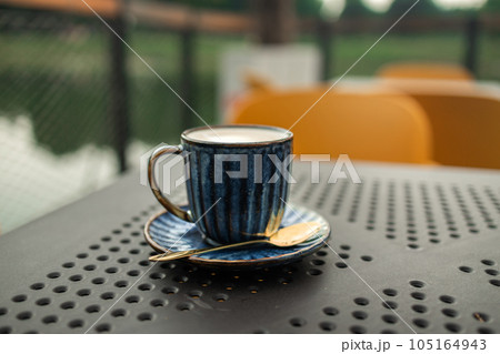 Hot coffee, milk, floral foam and aromatic coffee cups white cup is ready to serve customers in the morning, placed on a table in popular classic city coffee shop Hot coffee, milk, floral foam and aromatic coffee cups white cup is ready to serve customers in the morning, placed on a table in popular classic city coffee shop 105164943