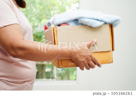 Clothes donations in cardboard box for volunteer. 105166261