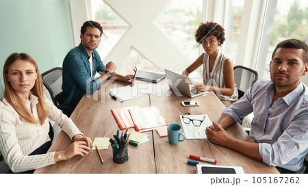 Successful team. Group of young business people looking at camera while working together in the modern office Successful team. Group of young business people looking at camera while working together in the modern office 105167262