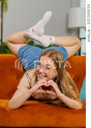 Happy young woman girl makes symbol of love showing heart sign to camera express romantic feelings 105168014