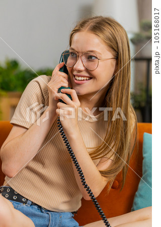 Woman making wired old-fashioned retro vintage telephone talking conversation with friends at home 105168017