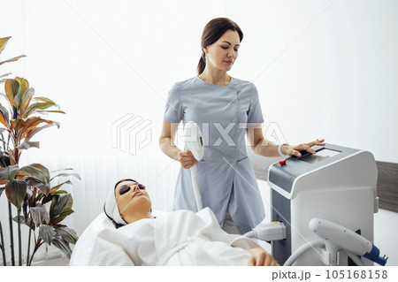 Portrait of relaxed young female client getting SMAS ultrasound face lifting massage Portrait of relaxed young female client getting SMAS ultrasound face lifting massage 105168158