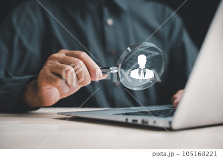 Exploring HRM Magnifier glass zooms in on manager icon among staff icons, symbolizing importance of human resource management in recruitment, leadership, and customer targeting. employees selection 105168221