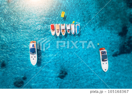 Aerial view of luxury yachts and boats on blue sea at sunrise 105168367