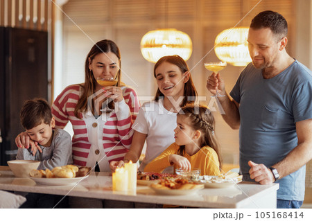 Big happy family is having lunch in dining room. Parents and children are having fun at home Big happy family is having lunch in dining room. Parents and children are having fun at home 105168414