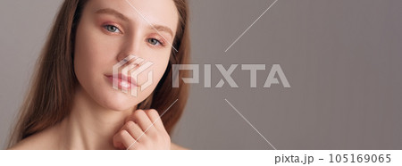 Smooth skin. Natural beauty care. Nude makeup. Nourishing face treatment. Pretty woman with nude color eyeshadow and lipstick posing isolated beige empty space. Smooth skin. Natural beauty care. Nude makeup. Nourishing face treatment. Pretty woman with nude color eyeshadow and lipstick posing isolated beige empty space. 105169065