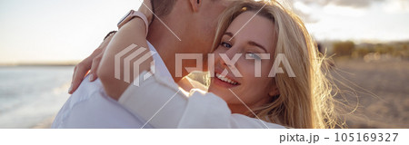 Close-up of beautiful woman hugging man on the beach Close-up of beautiful woman hugging man on the beach 105169327