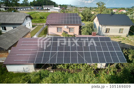 Photovoltaic solar panel fading away and shifting into metal supporting structure. Transition between metal rails and solar modules on roof of house. Concept of alternative energy sources. Aerial view 105169809