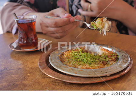 kunafa with a wipe cream on a plate . 105170033