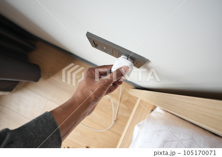 white color power cord cable plugged into wall white color power cord cable plugged into wall 105170071