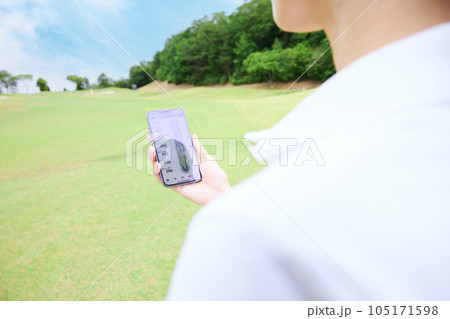 芝生の上でスマートフォンを操作する女性 芝生の上でスマートフォンを操作する女性 105171598