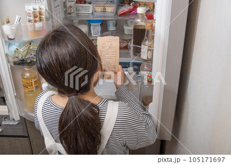 【冷蔵室からだしパックを取り出す主婦】 105171697