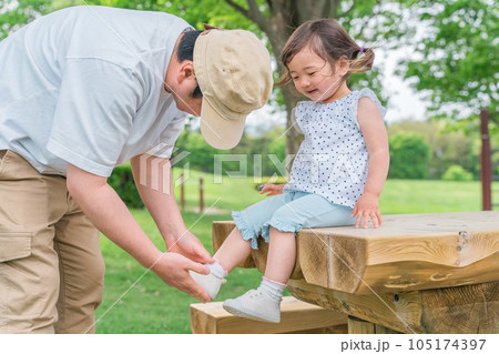 公園で靴を直す親子・靴を履かせるパパ 公園で靴を直す親子・靴を履かせるパパ 105174397