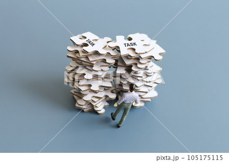 山積みの仕事に圧倒するビジネスマン（ミニチュア） 105175115