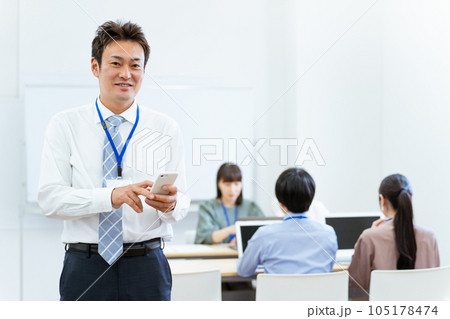 オフィスでスマホを使うアジア人ビジネスマン（中高年男性） 105178474