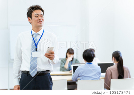 オフィスでスマホを使うアジア人ビジネスマン（中高年男性） 105178475