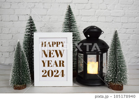 2024 Happy New Year Holiday background with pine tree and lantern on white brick wall 105178940