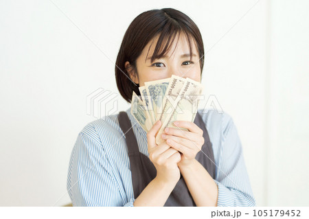 現金を持つ笑顔の女性の写真 105179452