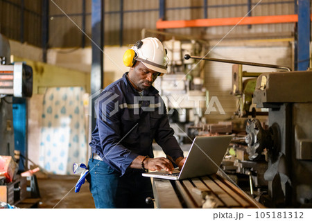 Male technician specialist with safety uniform using laptop Male technician specialist with safety uniform using laptop 105181312